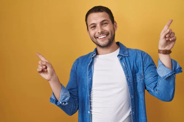 Hombre Hispano Pie Sobre Fondo Amarillo Sonriendo Confiado Señalando Con —  Fotos de Stock
