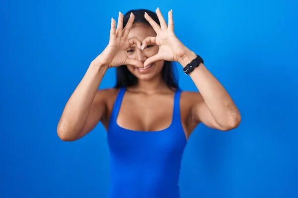 Mulher Hispânica Sobre Fundo Azul Fazendo Forma Coração Com Mão — Fotografia de Stock