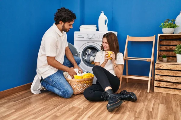 男男女女在洗衣房喝咖啡洗衣服 — 图库照片