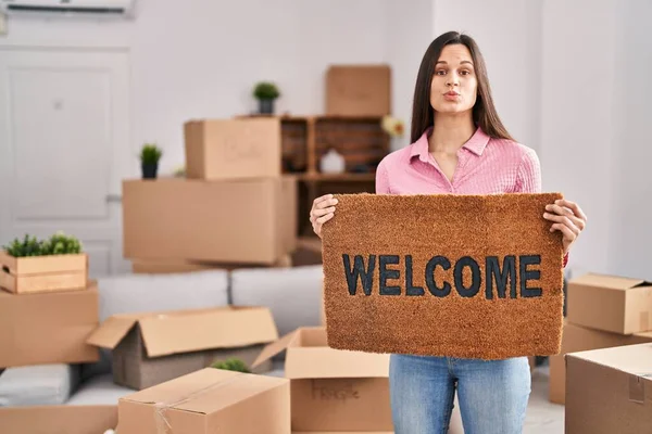 Young Hispanic Woman Holding Welcome Doormat New Home Puffing Cheeks —  Fotos de Stock