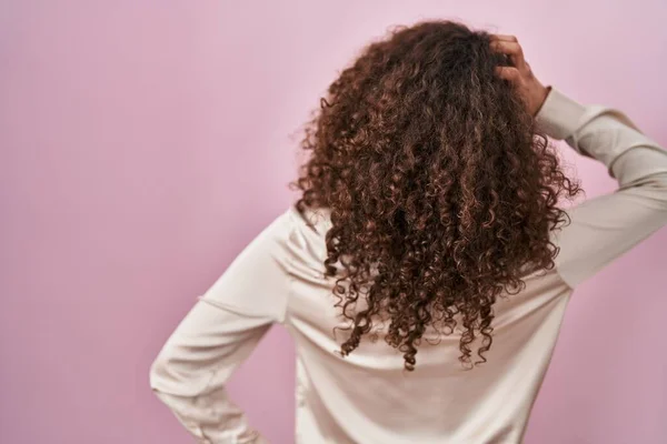 Kıvırcık Saçlı Spanyol Kadın Pembe Arka Planda Geriye Doğru Duruyor — Stok fotoğraf