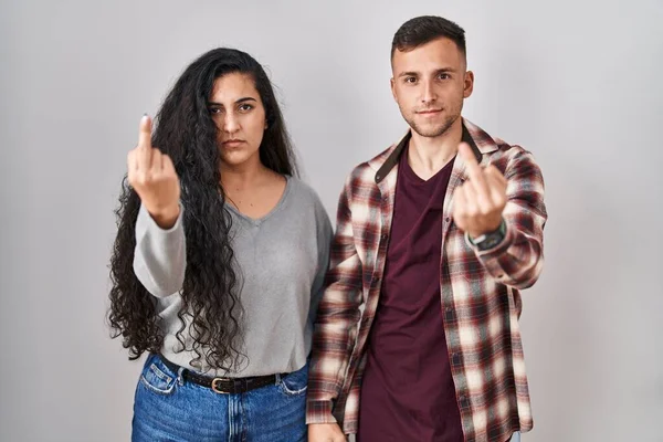 Young Hispanic Couple Standing White Background Showing Middle Finger Impolite — Zdjęcie stockowe