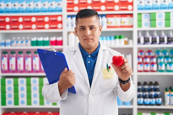 Joven Hombre Hispano Que Trabaja Farmacia Sosteniendo Corazón Relajado Con — Foto de Stock