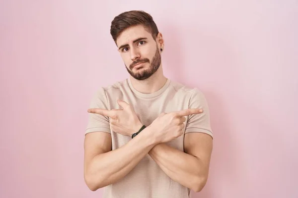 Hispanic Man Beard Standing Pink Background Pointing Both Sides Fingers — Stockfoto
