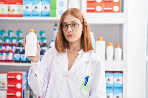 Young Redhead Woman Working Pharmacy Drugstore Holding Sun Screen Thinking — Foto Stock