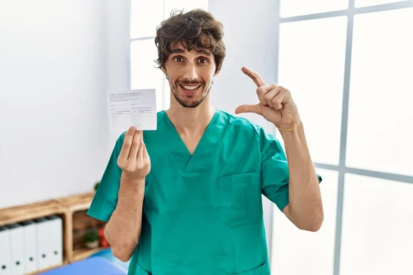 Young Hispanic Doctor Man Holding Covid Record Card Smiling Confident —  Fotos de Stock