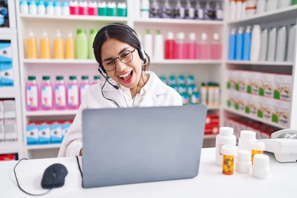 Young Arab Woman Working Pharmacy Drugstore Using Laptop Winking Looking — Stockfoto