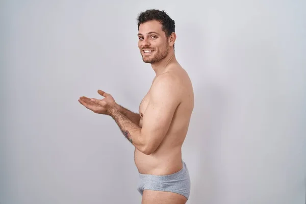 Junger Hispanischer Mann Steht Hemdlos Unterwäsche Und Zeigt Zur Seite — Stockfoto