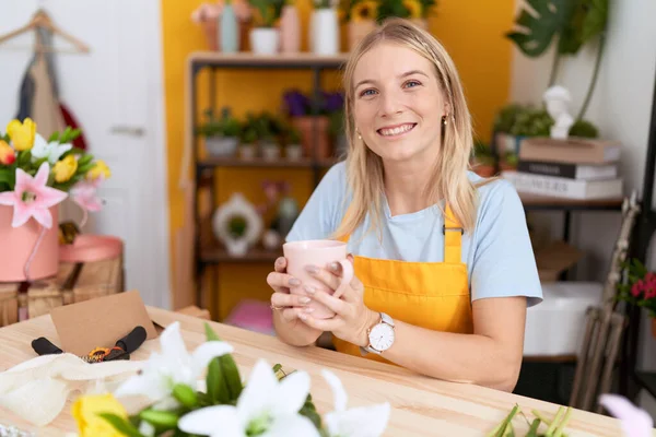 Young Blonde Woman Florist Smiling Confident Drinking Cup Coffee Flower — Stockfoto