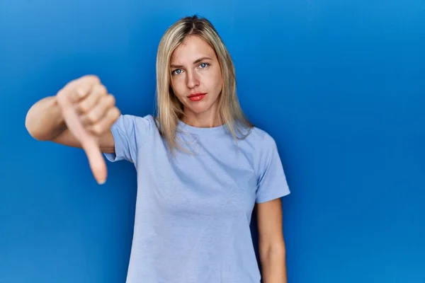 Mooie Blonde Vrouw Draagt Casual Shirt Blauwe Achtergrond Kijken Ongelukkig — Stockfoto