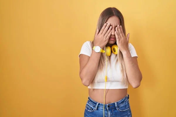Young Blonde Woman Standing Yellow Background Wearing Headphones Rubbing Eyes — Stock fotografie