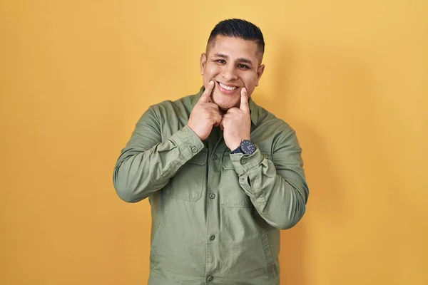 Hispanic Ung Mann Som Står Gul Bakgrunn Smiler Med Åpen – stockfoto