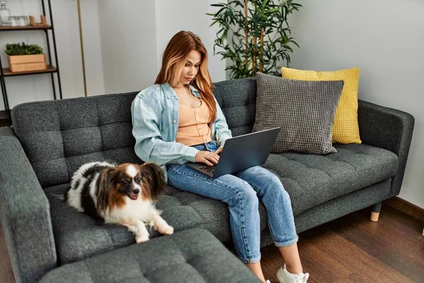Jovem Mulher Caucasiana Usando Laptop Deitado Sofá Com Cão Casa — Fotografia de Stock