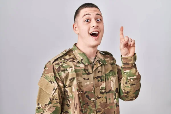 Young Man Wearing Camouflage Army Uniform Pointing Finger Successful Idea — Stock Photo, Image