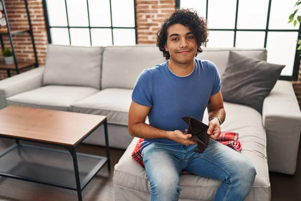 Jovem Hispânico Mostrando Carteira Vazia Sentado Sofá Casa — Fotografia de Stock