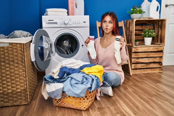 Young Caucasian Woman Doing Laundry Holding Socks Making Fish Face — Stock Photo, Image