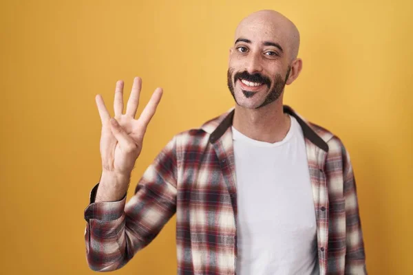 Латиноамериканец Бородой Стоит Желтом Фоне Показывает Пальцами Номер Четыре Улыбаясь — стоковое фото