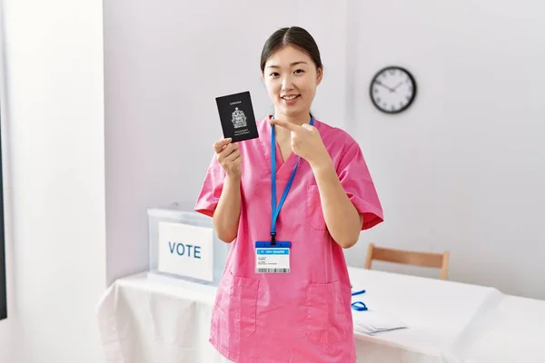 Молодая Женщина Медсестра Азии Выборах Держащая Канадский Паспорт Улыбаясь Показывая — стоковое фото