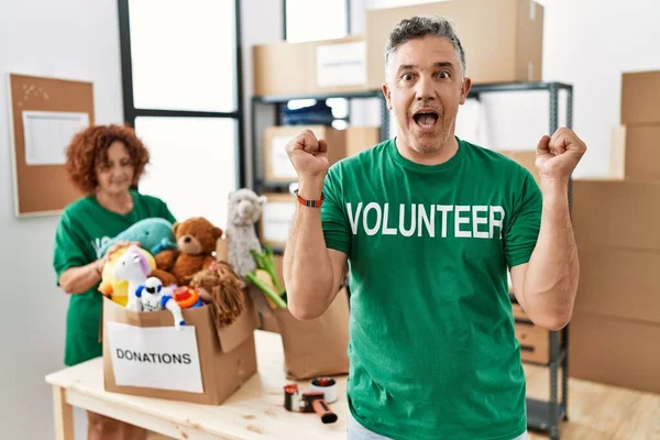 Middle Age Man Wearing Volunteer Shirt Donations Stand Celebrating Surprised — Stock Photo, Image