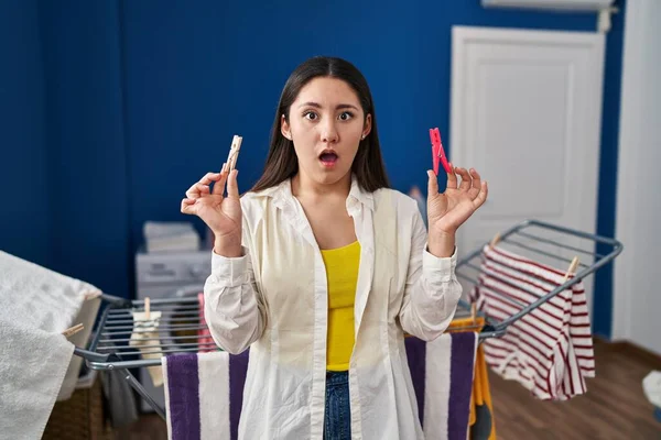 Young Latin Woman Holding Clothespins Hanging Clothes Clothesline Shock Face — Stockfoto