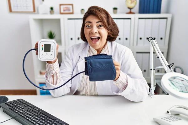 Middle Age Hispanic Doctor Woman Using Blood Pressure Monitor Celebrating — ストック写真