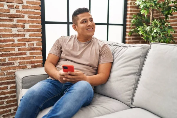 Jovem Latino Usando Smartphone Sentado Sofá Casa — Fotografia de Stock