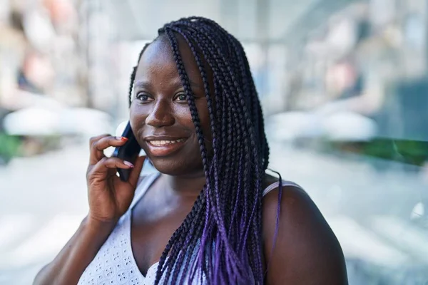アフリカ系アメリカ人の女性が路上でスマートフォンで自信を持って話しています — ストック写真