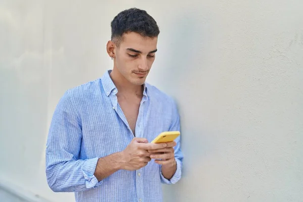 年轻的他的恐慌男人用智能手机在白色孤立的背景下严肃的表达 — 图库照片