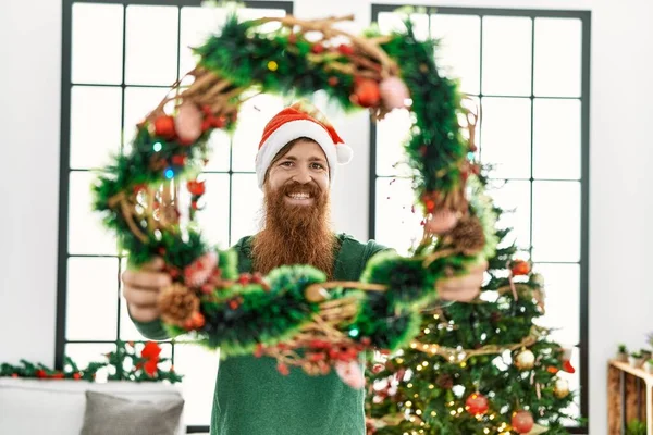 Jonge Roodharige Man Glimlachen Zelfverzekerde Holding Kerst Decoratie Thuis — Stockfoto