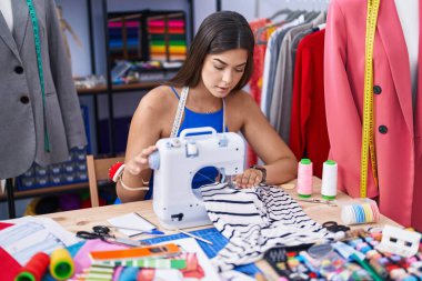 Terzide dikiş makinesi kullanan güzel İspanyol kadın.