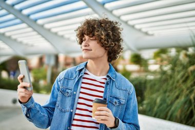 Genç İspanyol adam şehirde akıllı telefon kullanıyor.