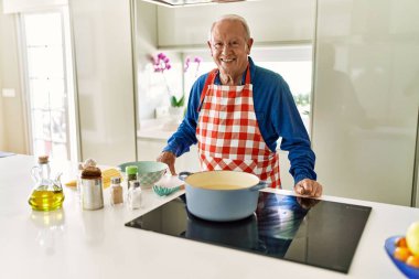 Son sınıf öğrencisi, mutfakta spagetti pişirme konusunda kendinden emin gülümsüyor.