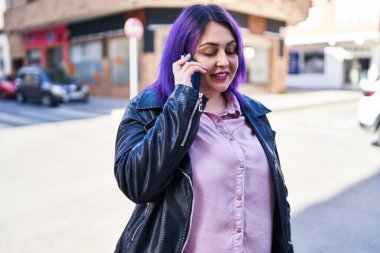 Young beautiful plus size woman smiling confident talking on the smartphone at street