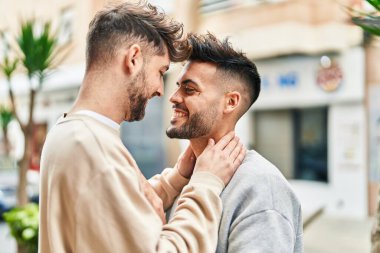 Young couple smiling confident hugging each other at street