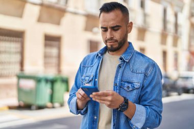 Sokakta akıllı telefon kullanan genç bir İspanyol.