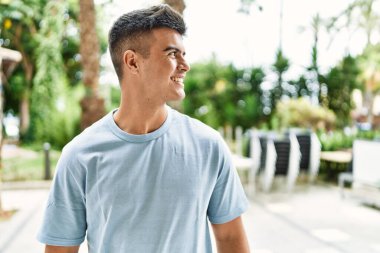 Sokakta kendinden emin gülümseyen İspanyol genç adam.