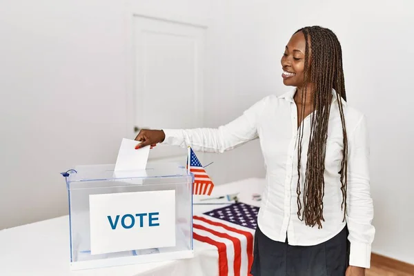 若いアフリカ系アメリカ人の有権者女性が選挙大学の投票箱に投票する — ストック写真