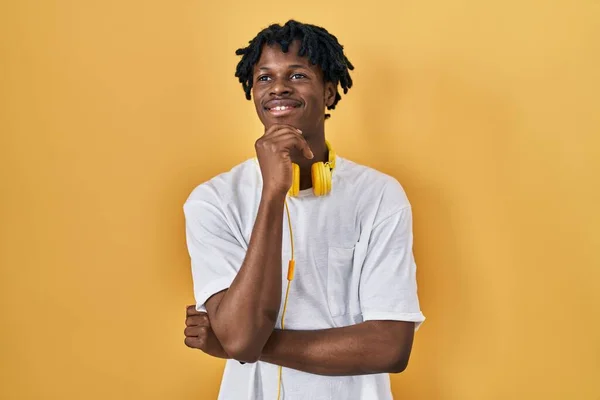 Young African Man Dreadlocks Standing Yellow Background Hand Chin Thinking — Stok fotoğraf