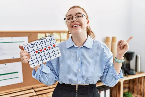 Junge Rothaarige Frau Mit Herzkalender Büro Lächelt Glücklich Und Zeigt — Stockfoto