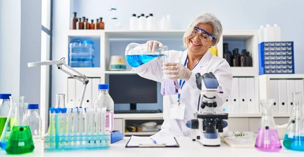 Middle Age Woman Wearing Scientist Uniform Pouring Liquid Test Tube — Stock fotografie