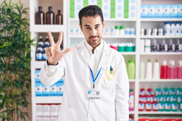 Handsome Hispanic Man Working Pharmacy Drugstore Showing Pointing Fingers Number — Zdjęcie stockowe