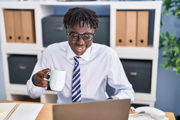 在办公室使用笔记本电脑喝咖啡的非裔美国人商人 — 图库照片