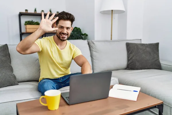 Young Man Beard Using Laptop Home Showing Pointing Fingers Number — Fotografia de Stock