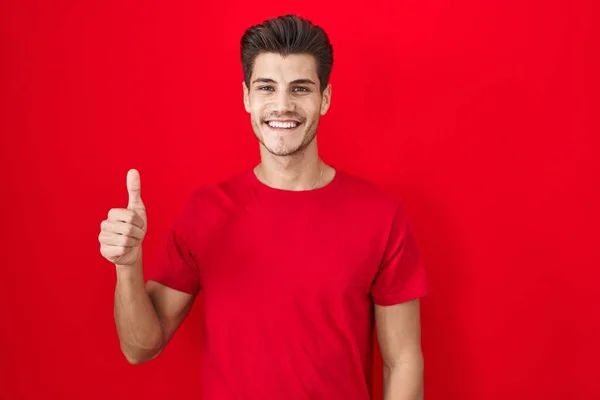 Kırmızı Arka Planda Duran Spanyol Genç Adam Elleriyle Mutlu Bir — Stok fotoğraf