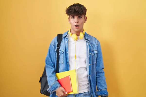 Ισπανόφωνος Έφηβος Φορώντας Σακίδιο Μαθητή Και Κρατώντας Βιβλία Στο Πρόσωπο — Φωτογραφία Αρχείου