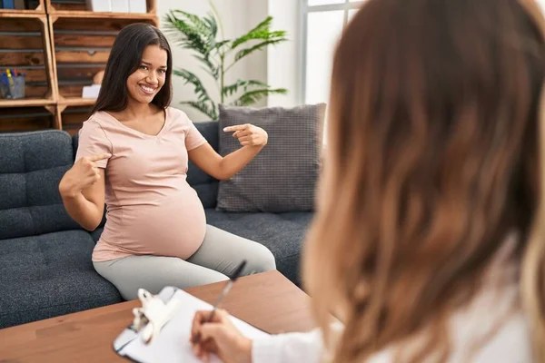 在治疗过程中 年轻的孕妇面带微笑 看上去很自信 用手指指着自己 自豪而快乐 — 图库照片
