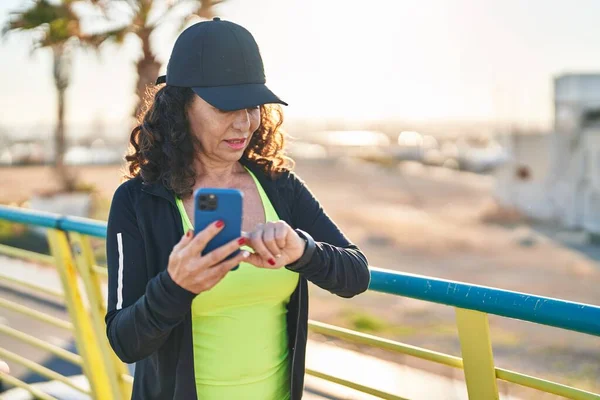 Middle Age Hispanic Woman Working Out Smartphone Promenade — Stockfoto