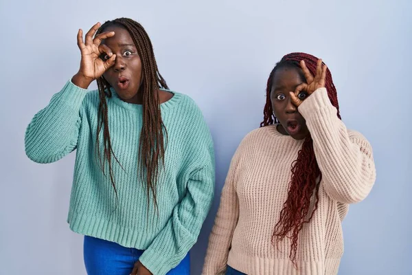 Две Африканки Стоящие Синем Фоне Делающие Нормальный Жест Шокированы Удивленным — стоковое фото
