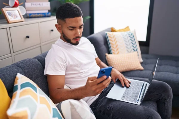 Jovem Latino Usando Smartphone Laptop Sentado Sofá Casa — Fotografia de Stock