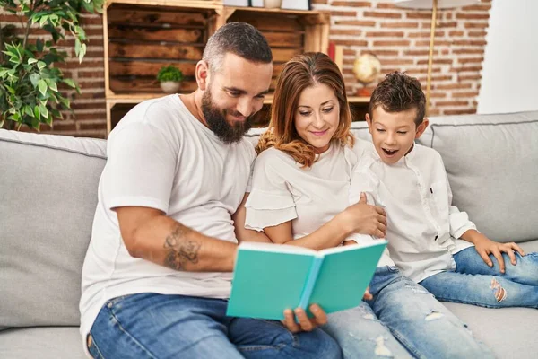 Family Reading Book Sitting Sofa Home — Foto de Stock